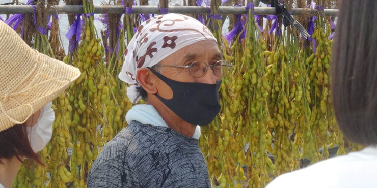 エコエリアのうがくたいで枝豆の栽培について説明する農家さんの画像